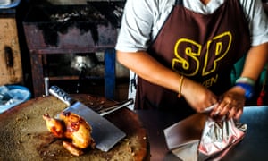 A young chef prepares roast chicken at SP Chicken restaurant in Chiang Mai, Thailand.