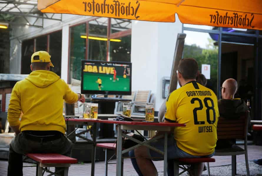 Fans in a bar watch the game between Borussia Dortmund and Bayern Munich.