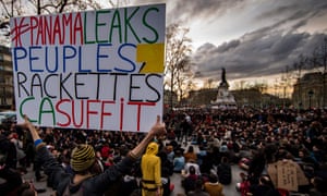 A protester holds a sign which reads ‘#Panama leaks, people, racketeering, that’s enough’ in Paris.