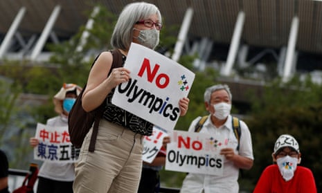 A demonstrator wearing a face mask holds a sign to protest against the Tokyo 2020 Olympic Games a year before the start of the summer games that have been postponed to 2021 due to the coronavirus outbreak, near Japan’s National Stadium on Friday.