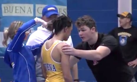 In this image taken from video provided by SNJToday.com, a Buena Regional high school wrestler, Andrew Johnson, gets his dreadlocks cut courtside minutes before his match in Buena, New Jersey. The incident sparked anger.