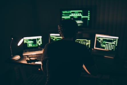 One hacker sitting in the dark room in front of his computers
