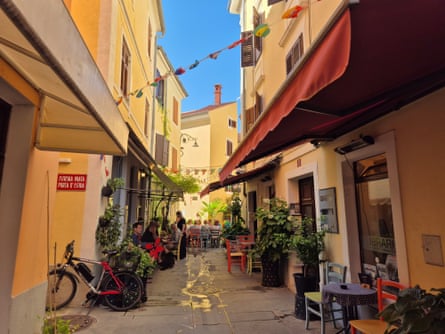 narrow street with tables and a bike outside