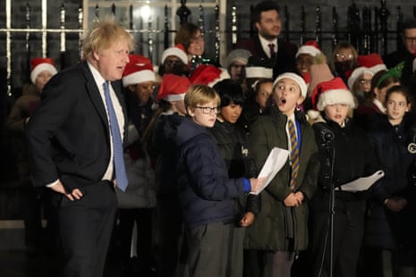 Boris Johnson listening to a children’s choir sings during the ceremony to switch on the Downing Street Christmas tree lights this evening.