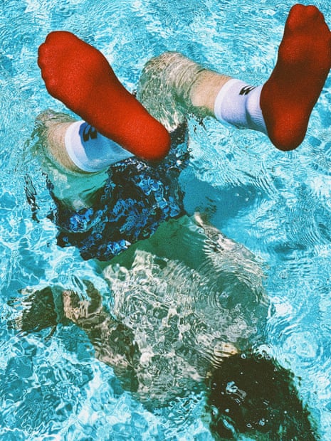 Photograph of person having dived into water in red and white socks
