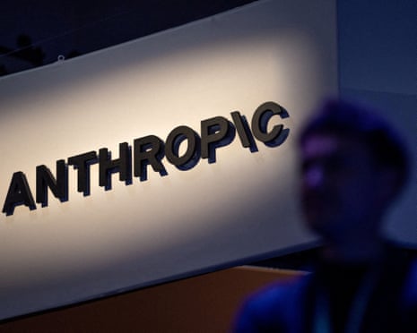 An Anthropic logo displayed behind a blurred out person speaking on a stage