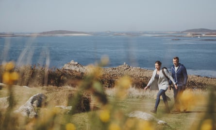 couple walking by sea in scilly isles
