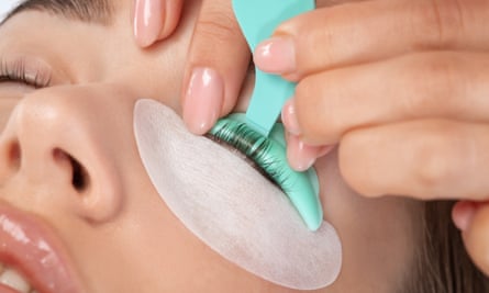 Makeup artist makes the procedure of lamination and dyeing of eyelashes to a beautiful woman in a beauty salon. Eyelash extensions. Eyelash lifting