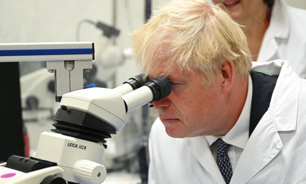 Boris Johnson looks through a microscope in July 2022.