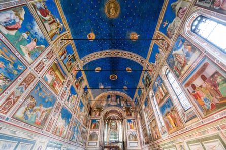 A beautiful blue frescoed ceiling, with paintings on the wall and stained-glass windows