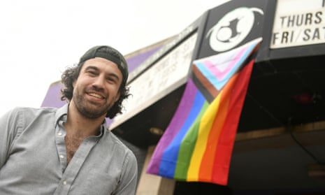 man standing in front of a pride flag