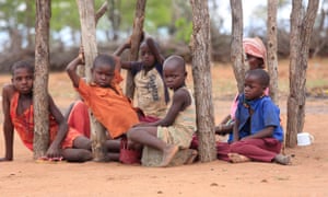 Children in Mafomoti village, in Zimbabwe’s Mwenezi district, wait while their mothers prepare their first and only meal of the day