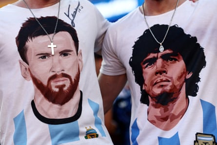 Two fans wear T-shirts with the faces of Lionel Messi and Diego Maradona.