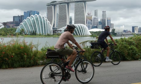Cyclists ride along Marina Bay overlooking the financial business district in Singapore on July 14, 2020