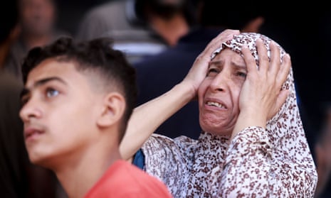 A Palestinian woman reacts at the scene of a strike at the Nuseirat refugee camp in the central Gaza Strip on Saturday.