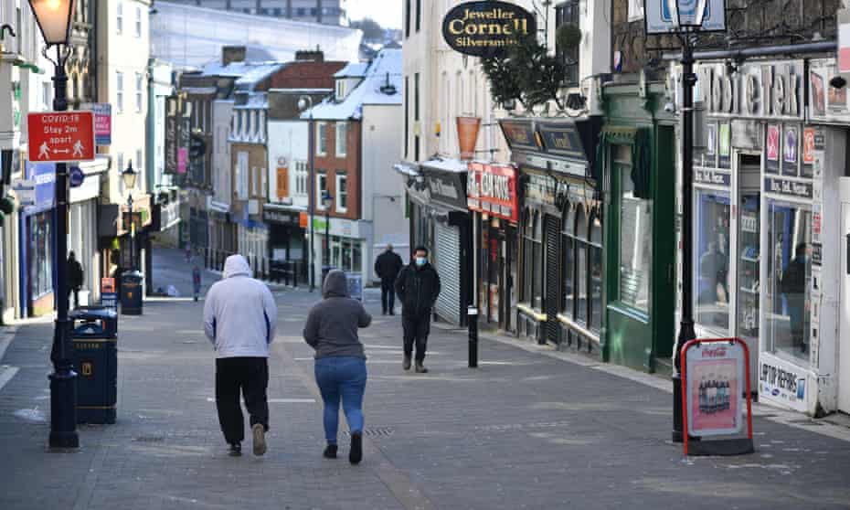 Pedestrians walk along a high street with the shops closed in Maidstone, southeast England as life continues in Britain’s third coronavirus lockdown that has closed all non-essential stores in an effort to suppress Covid-19 infections.