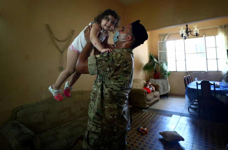 A soldier greets Christy Faraj Oghlo, 2, after delivering a food parcel to her grandmother Souzy Bedigian’s home, where Christy, her brother and their parents are staying, after an explosion on the Beirut port damaged their home, in Beirut, 16 August