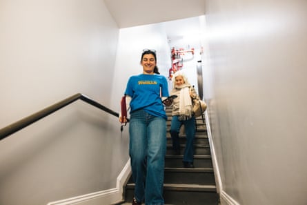 Mac Nicholas, 26, and Brenda Biddle, 73, walk down a set of stairs in an apartment building