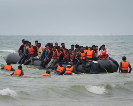 People thought to be migrants scramble to board a small boat near Wimereux in France.