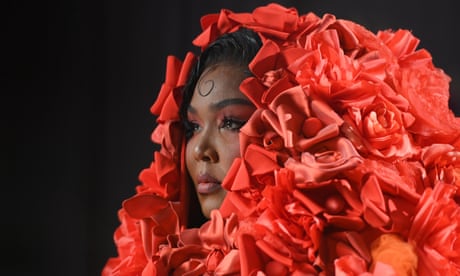 Lizzo wearing a red hooded floral dress