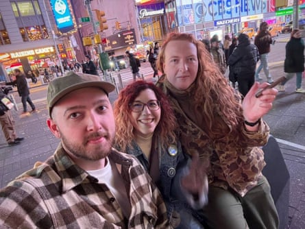 Three smiling people taking a selfie.