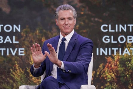 a man in a suit and tie sits on stage