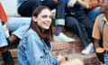 Portrait of smiling young female student sitting with multi-ethnic friends on steps at university