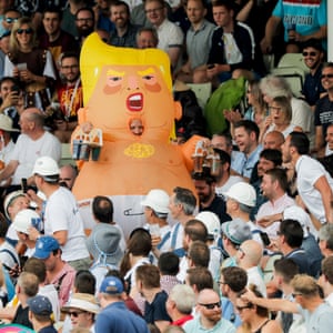 Un hombre con un traje de dirigible para bebés Donald Trump regresa al puesto de Hollies con cervezas.