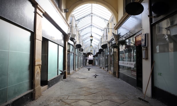 A discarded broom, closed shops and pigeons in the closed arcade in Dewsbury town centre.