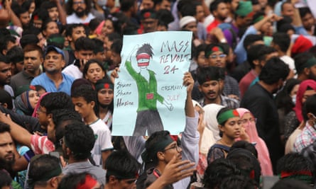 A crowd of young South Asian people, many wearing headbands in the colours of Bangladesh's flag. One holds a placard saying 'Mass revolt 24"