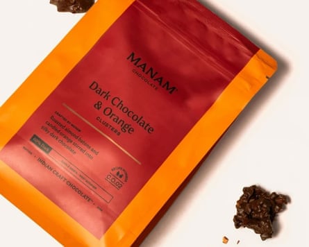 Image of an orange and red package of chocolate with orange dark chocolate clusters scattered beside it