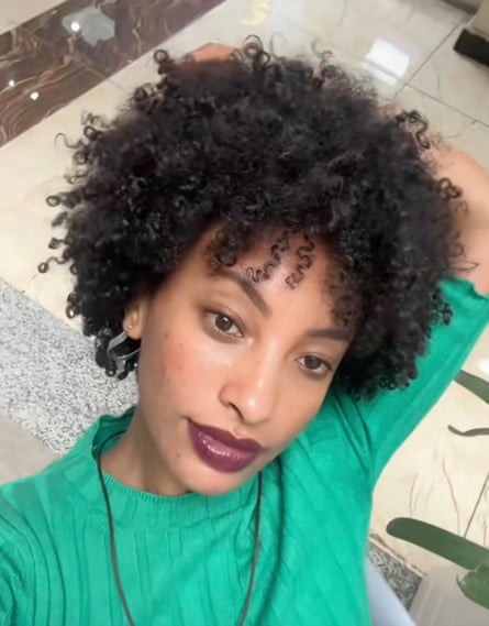 A woman in a green shirt poses for the camera.