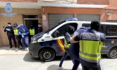 Suspects are led away after the raid in Almeria