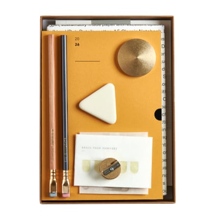 Various stationery items including yellow diary, notebook, pencils, wood sharpener, triangular eraser