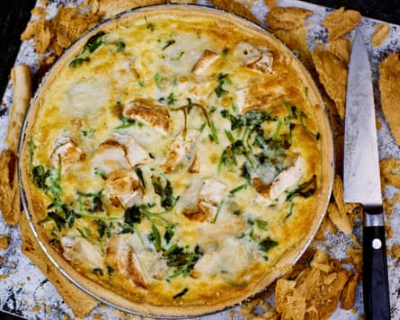 Watercress and goat’s cheese tart on a tray with a sharp knife next to it