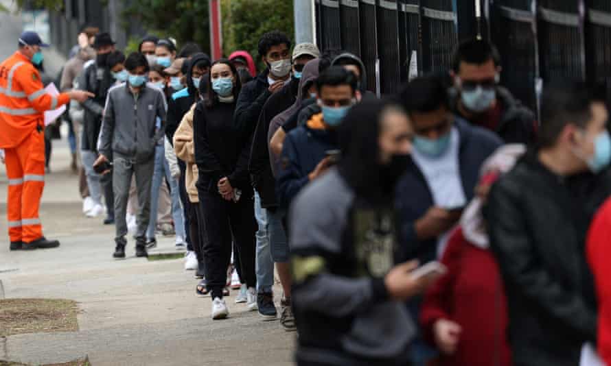 People wait in line outside a Covid-19 vaccination clinic in the Sydney suburb of Bankstown. NSW reported 882 new cases of Covid on Friday.