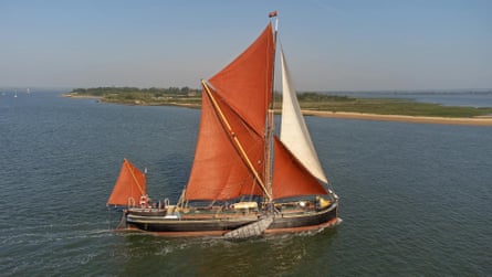 Large ld sailing barge with red sails on the sea