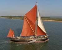 Large ld sailing barge with red sails on the sea