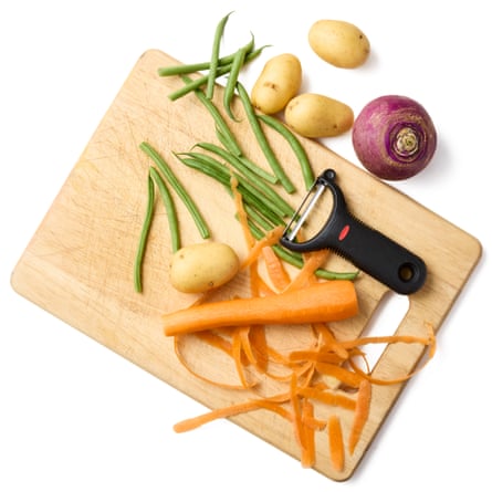 Vegetables on a chopping board with a peeler