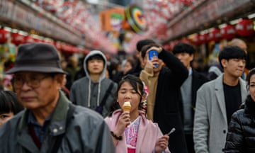 A girl eats an ice cream as she walks along Nakamise-dori, a shopping street near Senso-ji buddhist temple,  in Tokyo