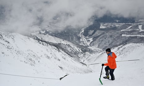A mountain guide checks snow ahead of a skiing event in Hakuba, western Japan. Some areas have recorded their lowest levels of snow for nearly 60 years.