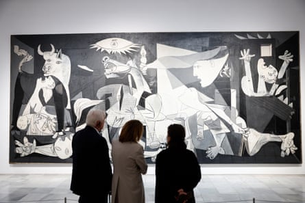 Guernica painting with the backs of three people stood in front
