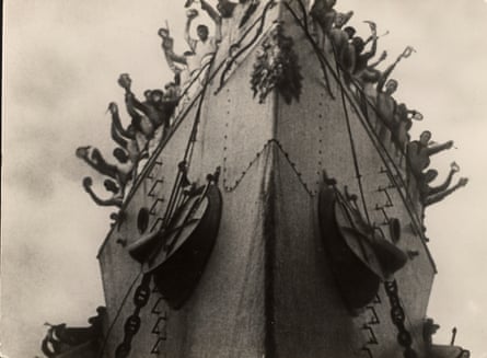 The crew cheering on the battleship, seen from below.