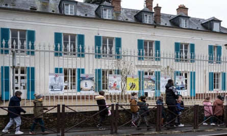 Children walk by signs discouraging smartphone use outside the village school.