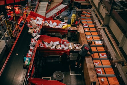 Workers sorting parcels at the Nova Poshta logistics hub in Kyiv, seen from above.