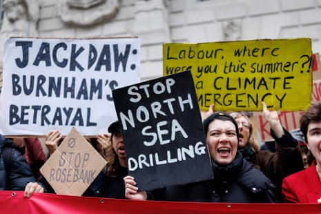 Climate protesters from Fossil Free London hold placards during a protest against the UK government's approval for drilling at the Jackdaw gas field in the North Sea, outside the Department for Energy Security and Net Zero in London, 21 October.