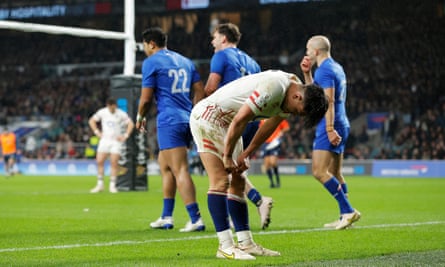 England’s fly-half Marcus Smith reacts as France’s wing Damian Penaud celebrates with teammates after scoring their sixth try.