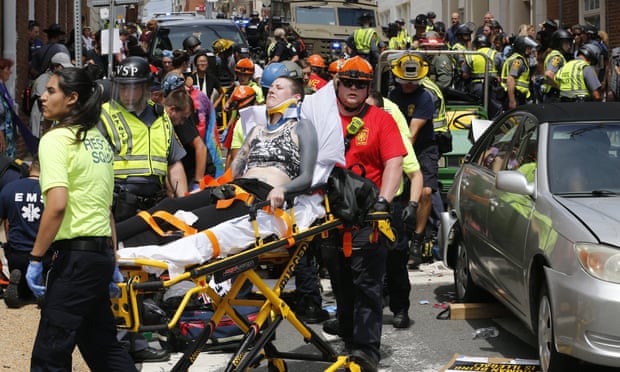 Rescue personnel help injured people after a car ran into a large group.