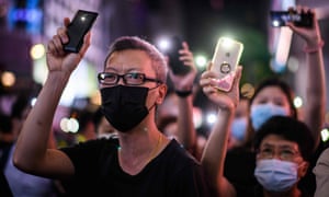 Pro-democracy protesters in Hong Kong hold up their mobile phones