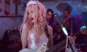 A female guitarist in pink dress and fluffy tiara performs on state at the Slam City club in St Petersburg, Russia.
